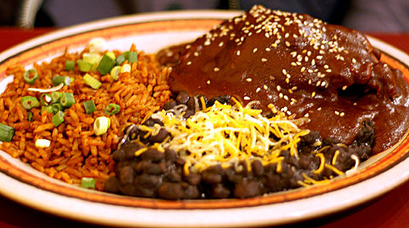 Mole Poblano servido con frijoles y arroz.
